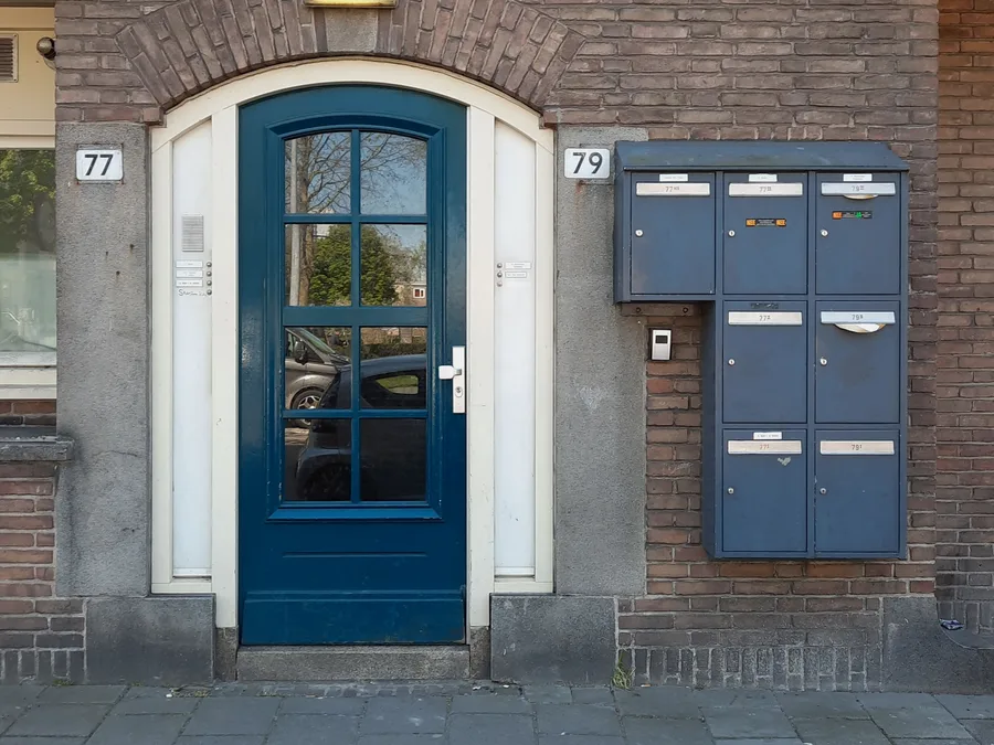 Hall d'entrée d'un immeuble bruxellois, porte vitrée et interphone — serrurier à Berchem-Sainte-Agathe